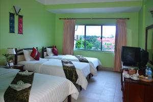 a hotel room with three beds and a television at Parklane Hotel in Siem Reap