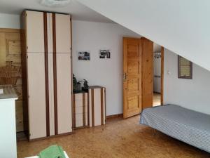 Cette chambre dispose d'un lit, d'un réfrigérateur et d'un escalier. dans l'établissement APARTMÁN ČESKÁ KANADA, à Nová Bystřice