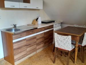 - une cuisine avec un évier et une table en bois dans l'établissement APARTMÁN ČESKÁ KANADA, à Nová Bystřice