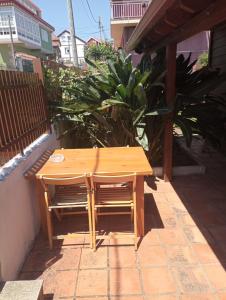 a wooden table and chairs on a patio at Casa de Madera in Cangas de Morrazo