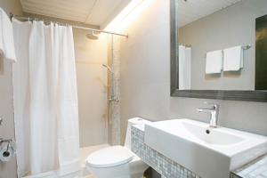a white bathroom with a sink and a toilet at Diamond Suites and Residences in Cebu City