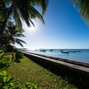 una playa con barcos en el agua y palmeras en Islands View - Mazor Beach Villas en Grand Gaube