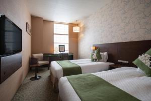 Giường trong phòng chung tại Hotel Vista Premio Kyoto Kawaramachi St