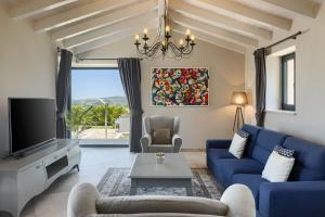 a living room with a blue couch and a tv at Luxury villa Edoardo with pool in Visinada in Vižinada