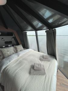 a bed in a tent with two towels on it at Ylläsjärvi iglu in Ylläsjärvi