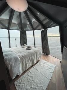 a bed in a room with a view of the water at Ylläsjärvi iglu in Ylläsjärvi