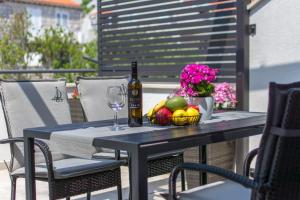 - une table avec une bouteille de vin et une corbeille de fruits dans l'établissement Apartment Gloria, à Dubrovnik