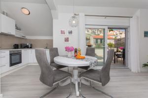- une cuisine et une salle à manger avec une table et des chaises dans l'établissement Apartment Gloria, à Dubrovnik