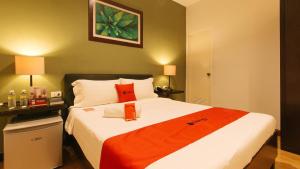 um quarto com uma cama com um cobertor vermelho em RedDoorz @ Gardenview Hotel GTower Angeles em Angeles
