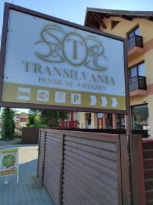una señal para una farmacia frente a un edificio en Pensiunea Transilvania, en Odorheiu Secuiesc