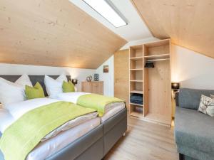 ein Schlafzimmer mit einem großen Bett und einem Sofa in der Unterkunft Alpine Holiday Home in Bramberg am Wildkogel with Garden in Bramberg am Wildkogel