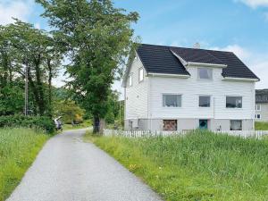 una casa blanca al lado de una carretera en Holiday home Bølandet 