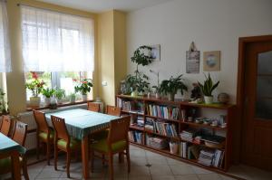 ein Esszimmer mit einem Tisch und einem Bücherregal in der Unterkunft Penzion Aura in Dvůr Králové nad Labem