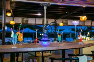 a wooden table with four wine glasses on it at Fitosinn Hotel in Paphos