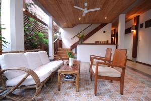 a living room with a couch and two chairs at Sala Prabang Hotel in Luang Prabang