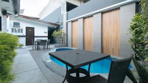 un patio con mesa negra y sillas en un edificio en RedDoorz @ Gardenview Hotel GTower Angeles en Ángeles