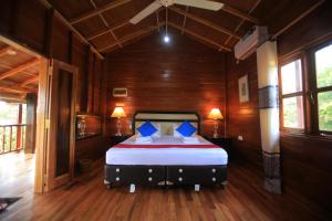 1 dormitorio con 1 cama en una habitación de madera en Jungle Hut Resort Sigiriya en Sigiriya