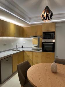 a kitchen with a table and a dining room at Luxury Apartment 105sqm Terrace Seafront WIFI Unlimited in Agadir