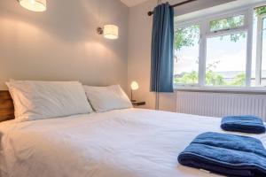 a bedroom with a large white bed with a window at Ferry Corner Cottage, Sudbourne in Woodbridge