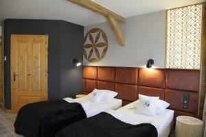 a hotel room with two beds and a door at Bajka Hotel & Resort in Grodziec