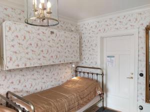 a bedroom with pink floral wallpaper and a bed at Anna´s Bed & Kitchen in Varberg