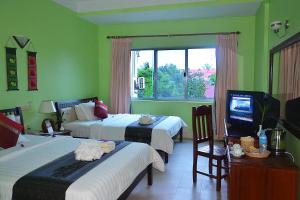 Cette chambre comprend deux lits et une télévision. dans l'établissement Parklane Hotel, à Siem Reap