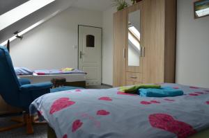 ein Schlafzimmer mit einem Bett und einem blauen Stuhl in der Unterkunft Penzion Aura in Dvůr Králové nad Labem