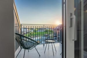 balcón con silla y mesa en Apartamenty Statki na Niebie en Rowy