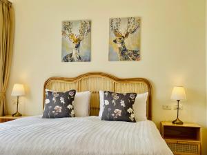 um quarto com uma cama com duas pinturas na parede em SpoonDrift Hostal Kenting em Nanwan