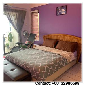 a bedroom with a bed and a purple wall at David beachside apartment in Port Dickson