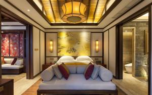 a bedroom with a large bed with a chandelier at Banyan Tree Chongqing Beibei in Chongqing