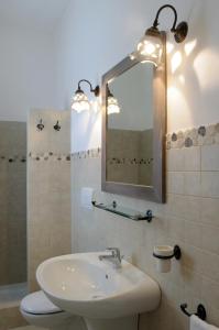La salle de bains est pourvue d'un lavabo et d'un miroir. dans l'établissement Il borgodellequerce CASA ULIVI PISCINA PRIVATA, à Martina Franca