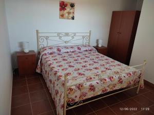 1 dormitorio con 1 cama con colcha de flores en Dependance Nonna Rosa, en Granelli
