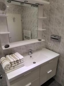 a white bathroom with a sink and a mirror at Alte Teestube Alte Teestube 57 in Norderney