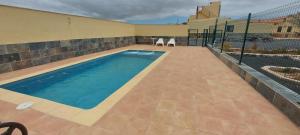 a swimming pool on a patio next to a building at El cortijo de Valverde in Lajares