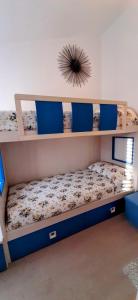 a bedroom with two bunk beds with blue pillows at La Dolce Vita - Casa Vacanza Tortolì-Arbatax in Tortolì