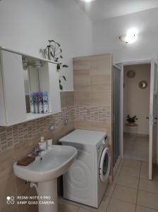 uma casa de banho com uma máquina de lavar roupa e um lavatório em Appartamento Giulio Cesare em Novara