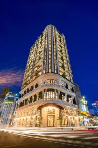 a tall building at night with a street at L'amor Boutique Hotel Quy Nhơn in Quy Nhon