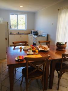 a kitchen with a wooden table with chairs and a dining room at Sandy toes in Yeppoon