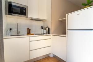 kuchnia z białymi szafkami i lodówką w obiekcie limehome Madrid Calle de Fomento - estancia temporal w Madrycie