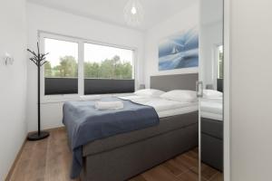 ein Schlafzimmer mit einem großen Bett und einem Fenster in der Unterkunft Lake House Sosnowy Las Mielno by Renters in Mielno