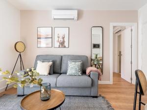 a living room with a gray couch and a table at limehome Madrid Calle de Fomento - Digital Access in Madrid