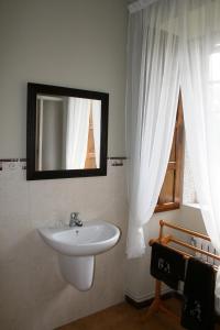 ein Badezimmer mit einem weißen Waschbecken und einem Spiegel in der Unterkunft Casa de Alicia Pontevedra Moraña Rías Baixas Casa Entera VT-PO-OOOO32 in Moraña + 64 Fotos