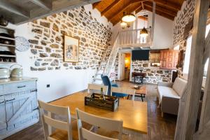 a dining room and living room with a stone wall at Villa Anastasia in Voládha