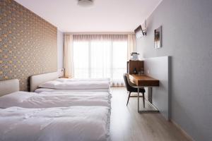 a room with three beds and a desk and a window at Rotonda in Gordola