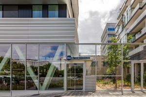 an external view of a building with glass doors at Best Western M-Treize Paris Asnieres in Asnières-sur-Seine