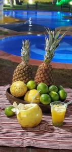 a tray of fruit on a table next to a pool at Residencial Sirius Canoa in Canoa Quebrada