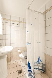a bathroom with a toilet and a shower curtain at VRAHOS - o ΒΡΑΧΟΣ in Agios Nikolaos