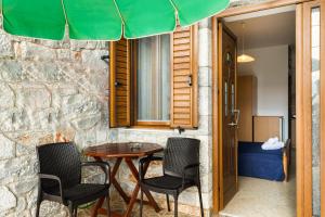 a patio with a table and chairs under an umbrella at VRAHOS - o ΒΡΑΧΟΣ in Agios Nikolaos