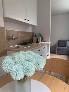 un vaso pieno di fiori appoggiato su un tavolo in cucina di Na Fali 17 - Sopot a Sopot